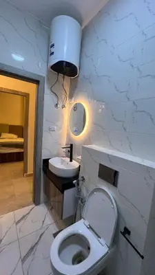 a bathroom with a white toilet and a sink at شقة فندقية امام المارينا 3 غرف 5 سراير in Hurghada