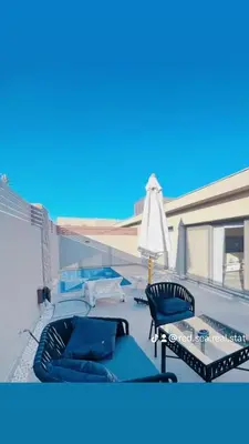 a patio with chairs and an umbrella on a balcony at Two Bedroom with Private pool in Hurghada