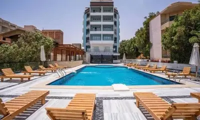 a large swimming pool with chairs and a building at Modern Studio with Pool and Private Beach Access in Hurghada