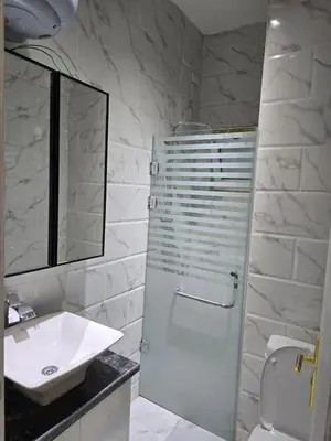 a white bathroom with a sink and a shower at Modern Studio with Pool and Private Beach Access in Hurghada