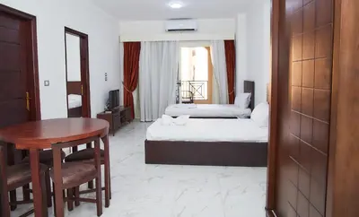 a hotel room with a bed and a table and a desk at Juliana Golden Beach Resort in Hurghada