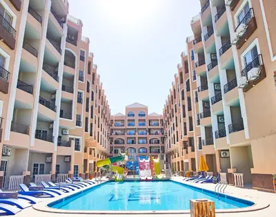 a swimming pool in the middle of a building with chairs and a slide at Juliana Golden Beach Resort in Hurghada