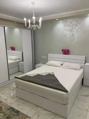 a bedroom with a large white bed and a chandelier at Happy Home Hurghada in Hurghada