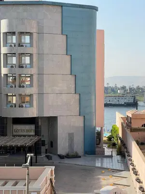 a view of a building with a river in front of it at Nile View Luxe Stay , Walk to Luxor Temple in Luxor