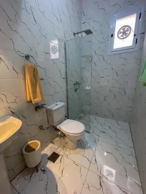 a bathroom with a toilet and a glass shower at el rabia - private rooms in Luxor