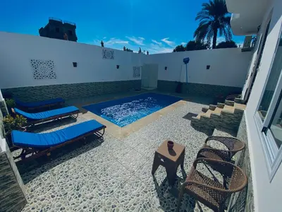 a swimming pool with lounge chairs and a table at el rabia - private rooms in Luxor