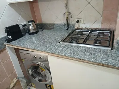 a kitchen counter with a stove and a washing machine at Arrabia in front of Beirut Hotel in Hurghada