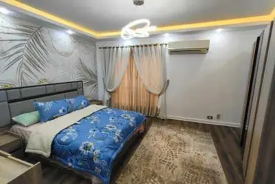 a bedroom with a blue bed and a window at الاقصر in Luxor