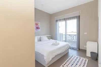 a white bedroom with a large bed and a window at 4 Bdr Villa with private heated pool in Sabina in Hurghada