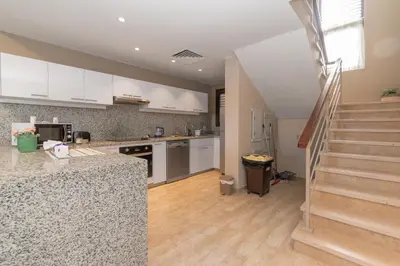 a kitchen with white cabinets and a staircase in a house at 4 Bdr Villa with private heated pool in Sabina in Hurghada