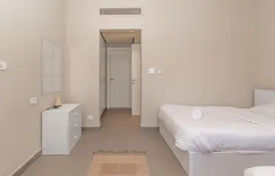 a white bedroom with a bed and a dresser and a mirror at 4 Bdr Villa with private heated pool in Sabina in Hurghada