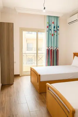 a bedroom with two beds and a window at casablanca resort in Hurghada