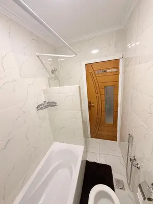 a white bathroom with a tub and a toilet at Oscar apartment 5 in Luxor