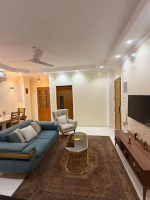 a living room with a blue couch and a table at Oscar apartment 5 in Luxor