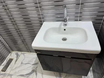 a white sink in a bathroom with gray tiles at Peace Homes in Quseir