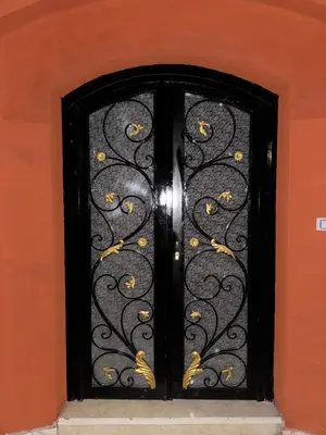 a black wrought iron door with gold flowers on it at Peace Homes in Quseir