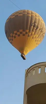 a yellow hot air balloon flying over a building at Nile Domes Guest House in Luxor