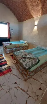 a room with two beds and a window at Nile Domes Guest House in Luxor