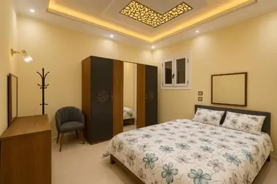 a bedroom with a bed and a desk and a chair at Oscar Apartment 2 in Luxor