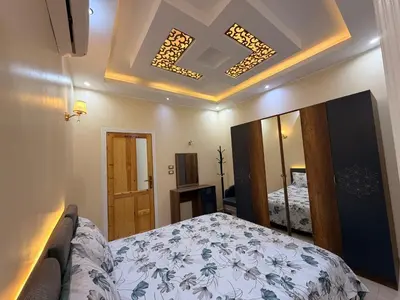 a bedroom with a bed and a mirror at Oscar Apartment 2 in Luxor