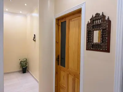 a hallway with a wooden door and a mirror at Oscar Apartment 2 in Luxor