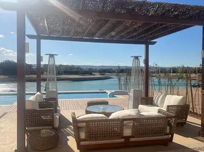 a pavilion with chairs and a table and a pool at Spacious outdoor area featuring a swimming pool ! in Hurghada