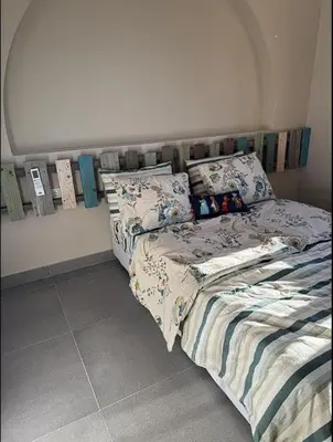 a bedroom with a bed and pillows on it at Spacious outdoor area featuring a swimming pool ! in Hurghada