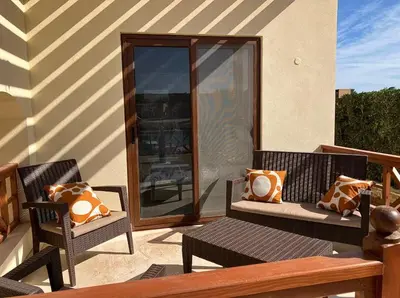 a patio with two chairs and a table and a window at Spacious outdoor area featuring a swimming pool ! in Hurghada