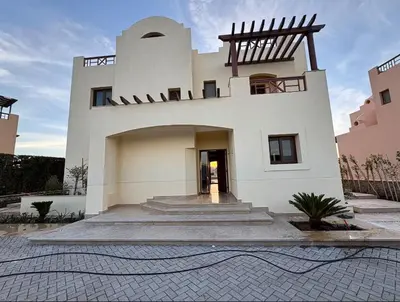 a large white building with a staircase in front of it at Spacious outdoor area featuring a swimming pool ! in Hurghada