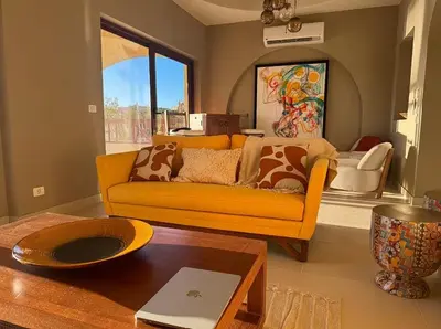 a living room with a yellow couch and a table at Spacious outdoor area featuring a swimming pool ! in Hurghada
