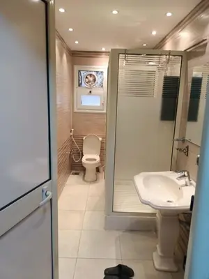 a bathroom with a shower and a toilet and a sink at Furnished apartment for rent in Abū Tīj
