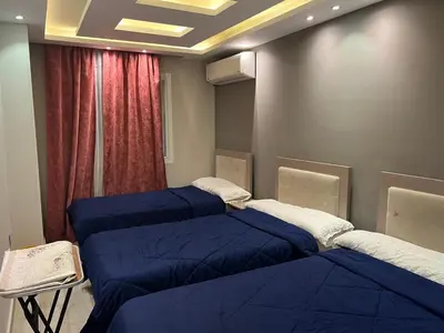 a room with four blue beds and a window at Furnished apartment for rent in Abū Tīj