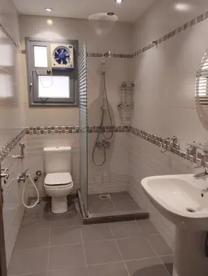 a bathroom with a shower and a toilet and a sink at Furnished apartment for rent in Abū Tīj