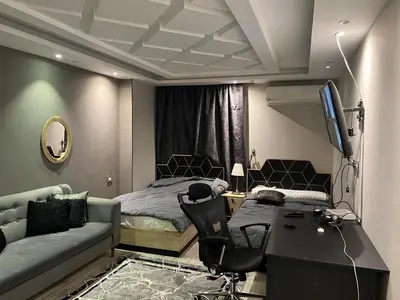 a bedroom with a bed and a desk and a couch at Furnished apartment for rent in Abū Tīj
