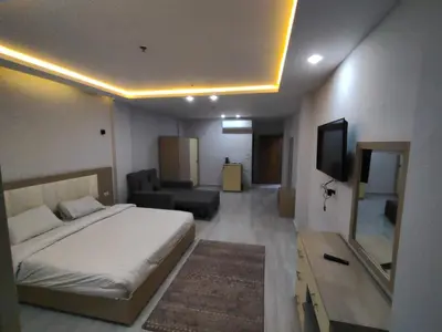 a bedroom with a bed and a couch and a television at فندق ميراج باي اكوا بارك in Hurghada