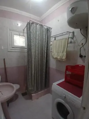 a bathroom with a washing machine and a sink at Rent Mubarak 2 in Hurghada