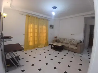 a living room with a couch and a yellow curtain at Rent Mubarak 2 in Hurghada