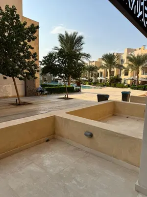 a bench in a courtyard with palm trees and buildings at M10-2b-04 mangrove in Hurghada