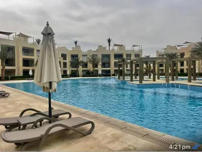 a umbrella and a chair next to a swimming pool at M10-2b-04 mangrove in Hurghada