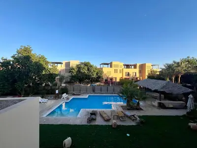 a swimming pool with lounge chairs and a resort at Cozy South Marina 2Bdr with Pool Access in Hurghada