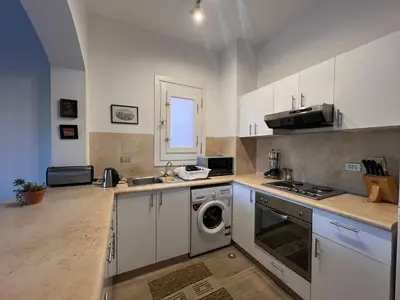 a kitchen with white cabinets and a washing machine at Cozy South Marina 2Bdr with Pool Access in Hurghada