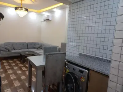 a living room with a couch and a washing machine at Apartment compound west sayed Al kawthar in Hurghada
