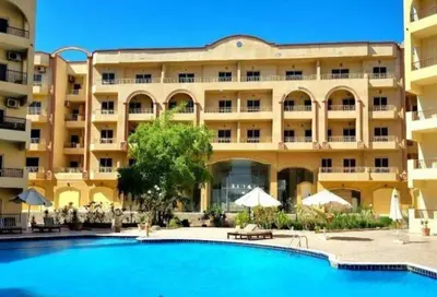 a hotel with a swimming pool in front of a building at Apartment compound west sayed Al kawthar in Hurghada