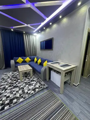 a living room with a blue couch and a table at Interstar Luxury Apartments in Hurghada