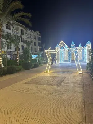 a person standing in front of a building with lights at Interstar Luxury Apartments in Hurghada