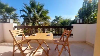 a wooden table and two chairs on a balcony at Scenic Cosy Nest - Infinity Pool - Ancient Sands in Hurghada