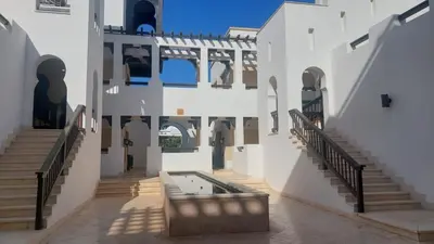 a courtyard with a pool in a building with stairs at Scenic Cosy Nest - Infinity Pool - Ancient Sands in Hurghada