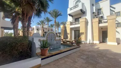 a villa with a swimming pool and palm trees at Scenic Cosy Nest - Infinity Pool - Ancient Sands in Hurghada