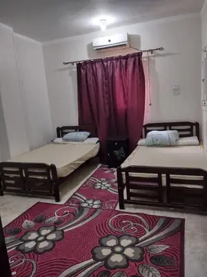 two beds in a room with a red carpet at شقة الغردقة in Hurghada