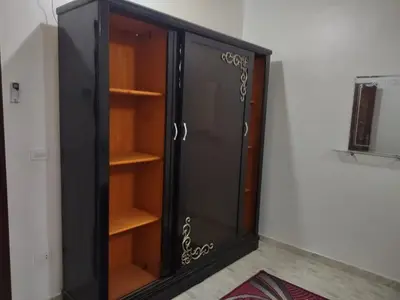 a black cabinet with wooden shelves in a room at شقة الغردقة in Hurghada